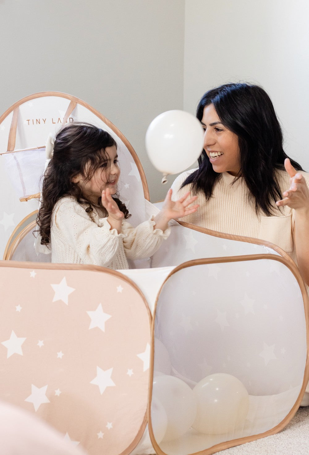 Parent and child playing together in the Tiny Land® play tunnel